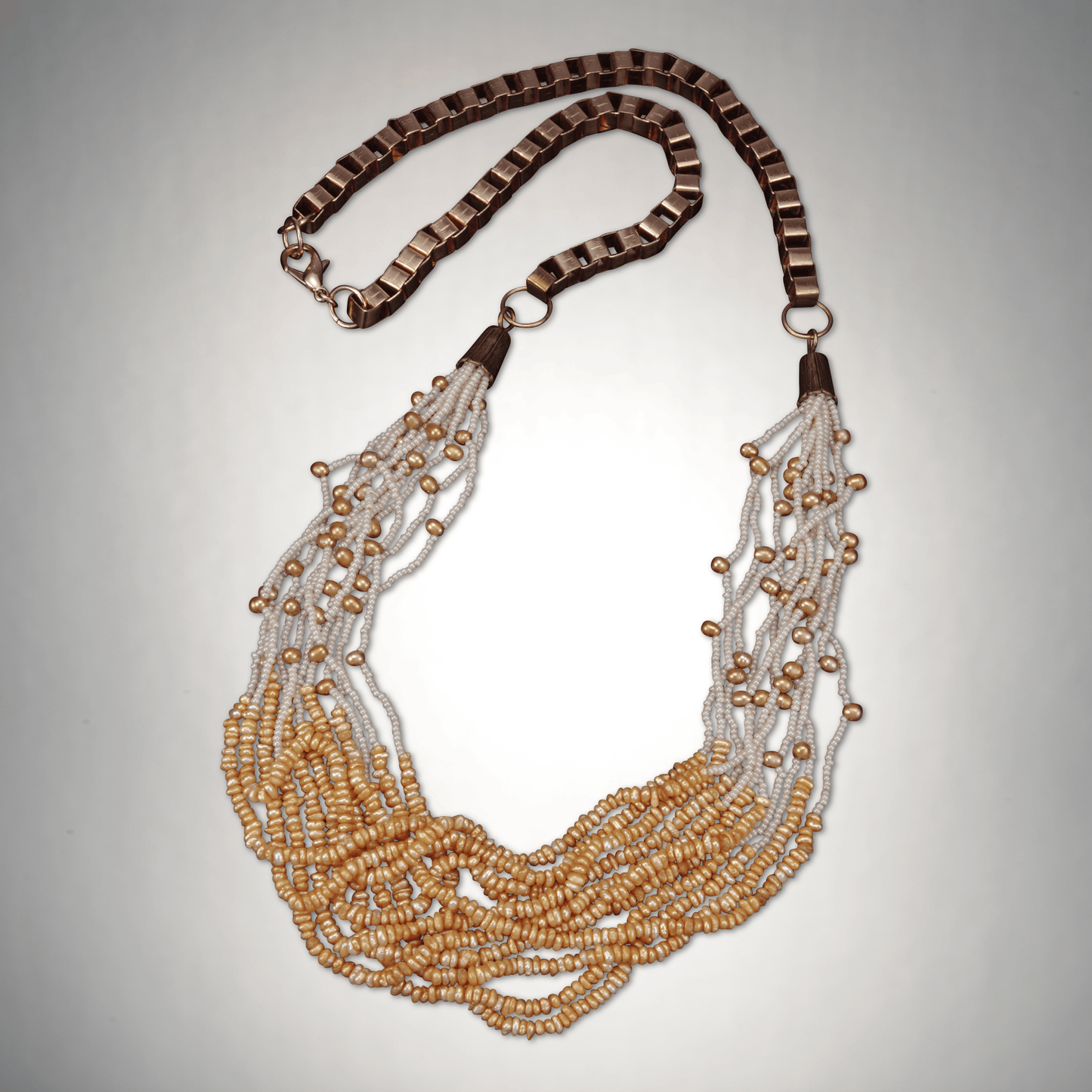 36"-inch multi-strand necklace with dusty orange keshi pearls on copper chain, tribal-inspired design with vibrant layers.