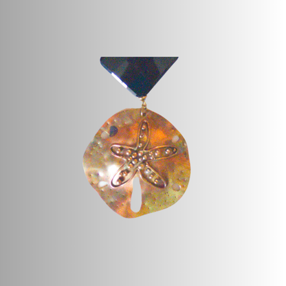 Close-up of brass dollar pendant with bubbles on gray background.