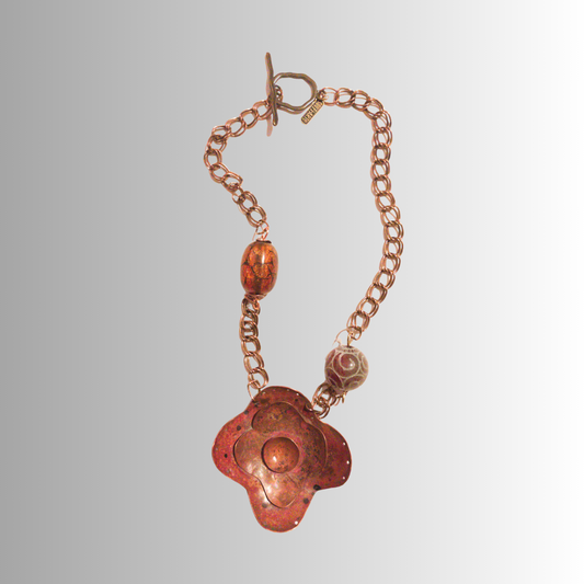 Hand-forged flame-painted copper flower necklace with carved jade bead and brass chain from SOUFiiARTe.