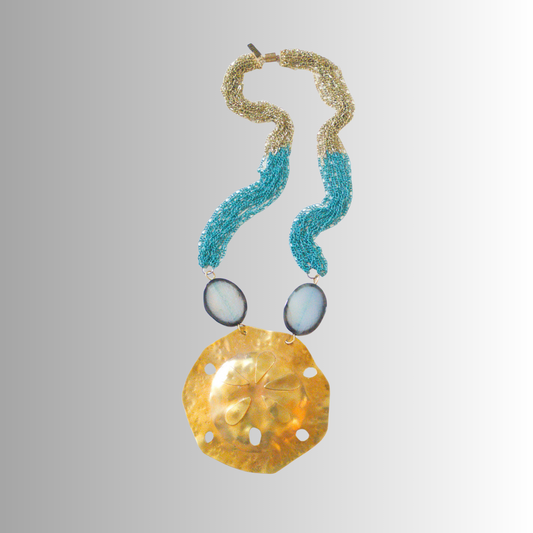 Oversized hammered brass sand dollar necklace with pale blue agate and turquoise-brass multi-chains, handcrafted by SOUFiiARTe for the Resort Collection. 