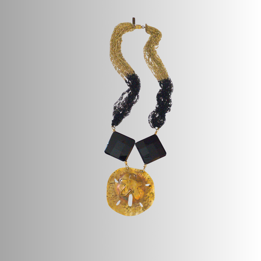 Handcrafted brass sand dollar necklace with black faceted onyx and black-gold multi-strand chains part of the SOUFiiARTe Resort Collection.